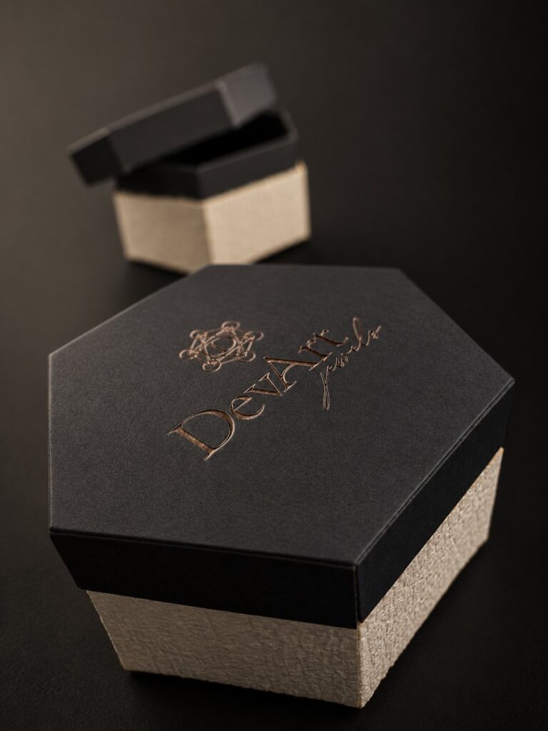 Packaging DevArt Jewels esagonale in fibra di ananas con logo in oro rosa